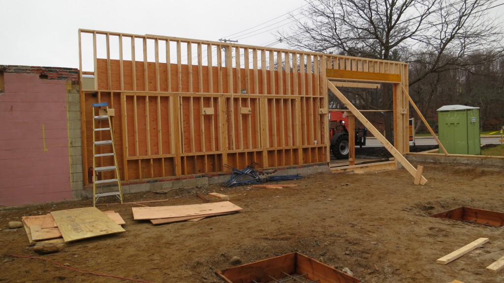 New exterior wall framing has begun to support the new raised roof structure.